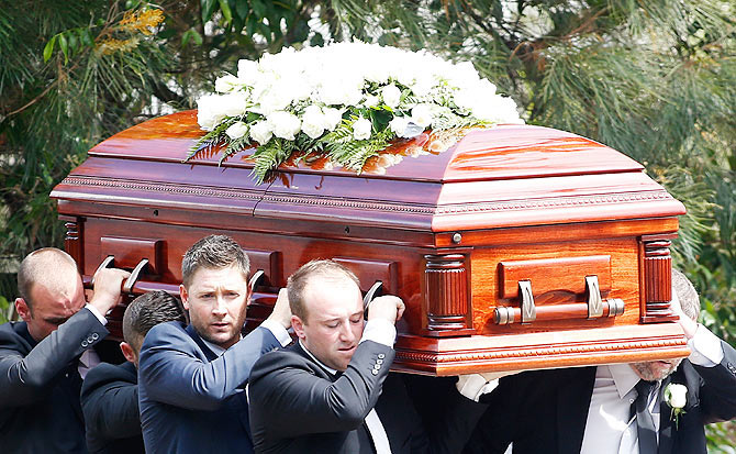 Australian Test Cricket captain Michael Clarke and Jason Hughes carry the coffin of Australian cricketer Phillip Hughes during the funeral service in Macksville, near Sydney on December 3