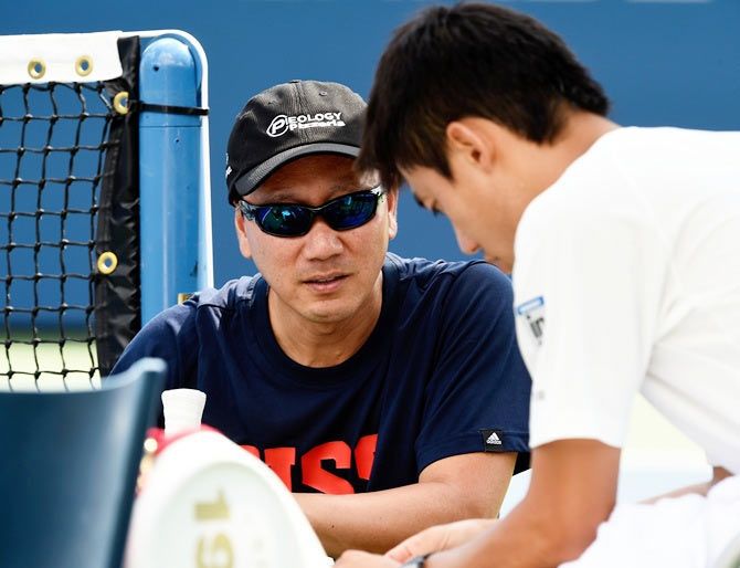 Kei Nishikori (right) talks with coach Michael Chang during a practice session