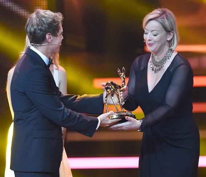 Sabine Kehm, manager of Michael Schumacher, accepts the award on behalf of Michael Schumacher from   Sebastian Vettel during the Bambi Awards 2014