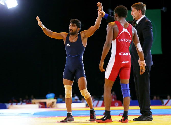 Yogeshwar Dutt (L) of India celebrates victory in the Men's FS 65 kg Gold medal match against Jevon Balfour of Canada during the Glasgow 2014 Commonwealth Games on July 31
