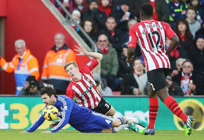 Cesc Fabregas of Chelsea goes down in the penalty area after a challenge by Matt Targett of Southampton and is booked for diving during their English Premier League match at St Mary's Stadium on Sunday