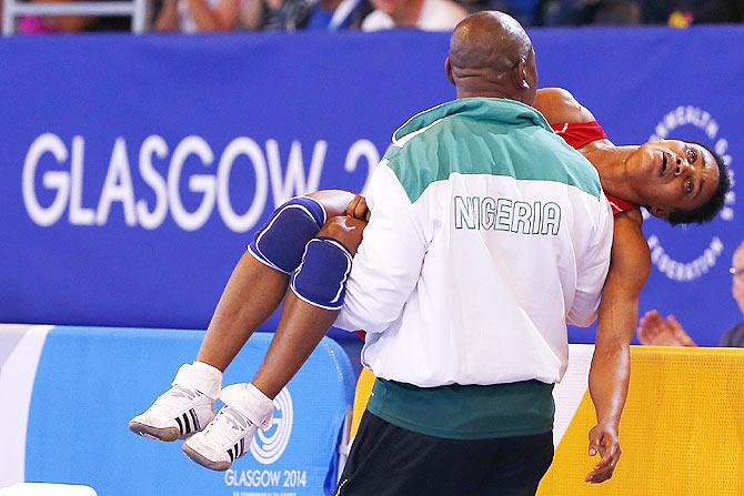  Ifeoma Nwoye of Nigeria is carried away by her coach after she lost her women's freestyle 55kg wrestling semi-final to Brittanee Laverdure of Canada at the 2014 Commonwealth Games in Glasgo