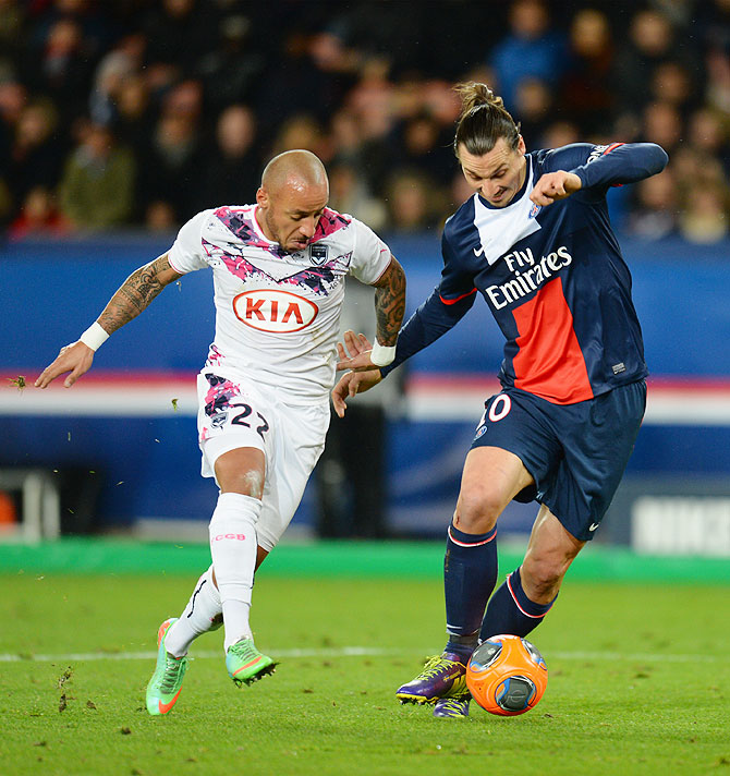 Zlatan Ibrahimovic of Paris Saint-Germain FC is challenged by Julien Faubert of Girondins de Bordeaux during their Ligue 1 match at Parc des Princes stadium in Paris on Friday
