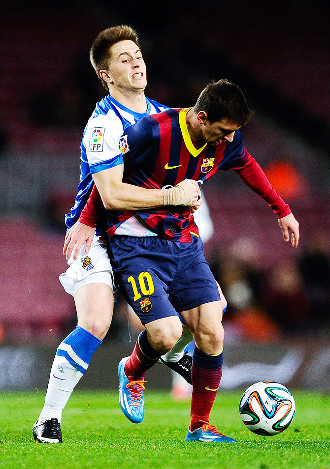 Lionel Messi of FC Barcelona is challenged by Gaztanaga of Real Sociedad during their Copa del Rey Semi-Final first leg match at Camp Nou in Barcelona on Wednesday