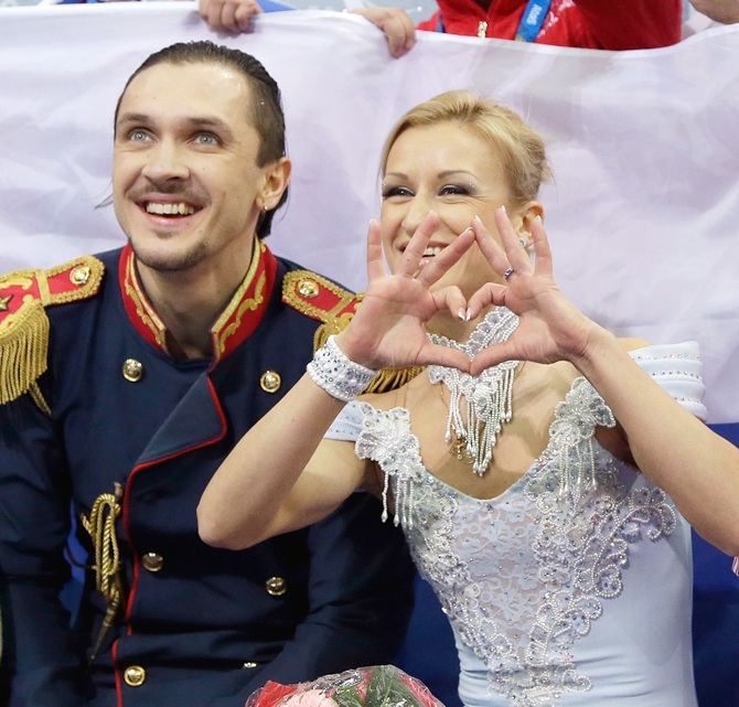 Maxim Trankov and Tatiana Volosozhar of Russia wait for their score after competing in Figure Skating
