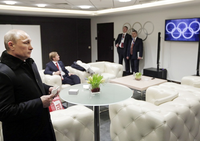 Russian President Vladimir Putin (left) waits in the presidential lounge