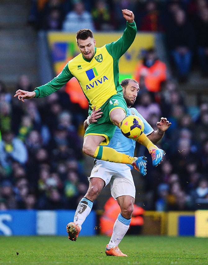 Anthony Pilkington of Norwich City (left) and Pablo Zabaleta of Manchester City vie for possession during their match at Carrow Road in Norwich on Saturday