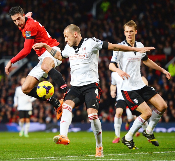 Robin van Persie of Manchester United competes with John Heitinga of Fulham