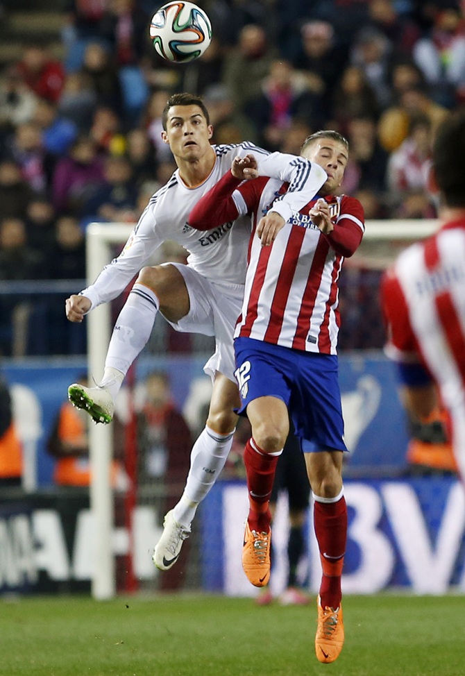 Atletico Madrid's Tobias Albertine Maurits Alderweireld, right, fights for the ball with Real Madrid's Cristiano Ronaldo