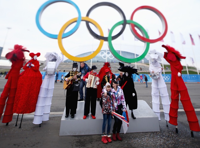 Fans take pictures in front of the Olympic rings during day four of the Sochi 2014 Winter Olympics.