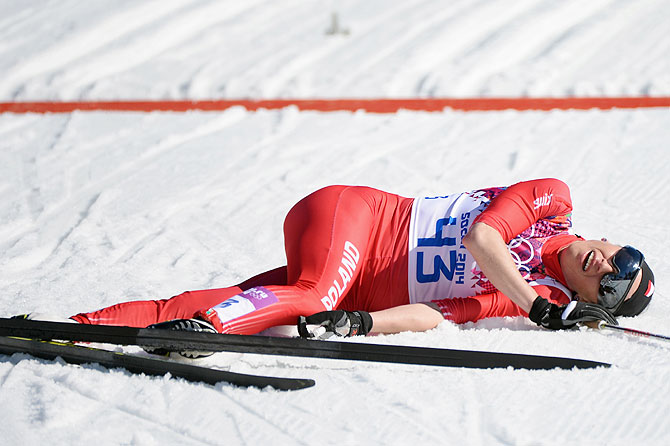 Justyna Kowalczyk of Poland collapses at the finish line first in the Women's 10 km Classic at Laura Cross-country Ski & Biathlon Center in Sochi on Thursday