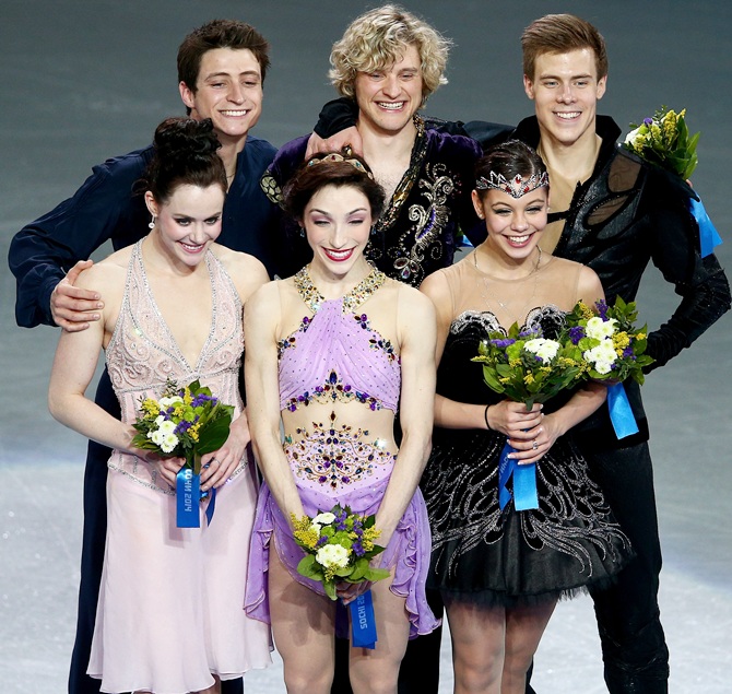 From left, Silver medalists Tessa Virtue and Scott Moir of Canada, gold medalists Meryl Davis and Charlie White of the United States, and bronze medalists Elena Ilinykh and Nikita Katsalapov of Russia celebrate on the podium during the flower ceremony for the Figure Skating Ice Dance.