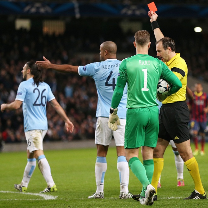 Referee Jonas Eriksson shows a red card to Martin Demichelis of Manchester City.