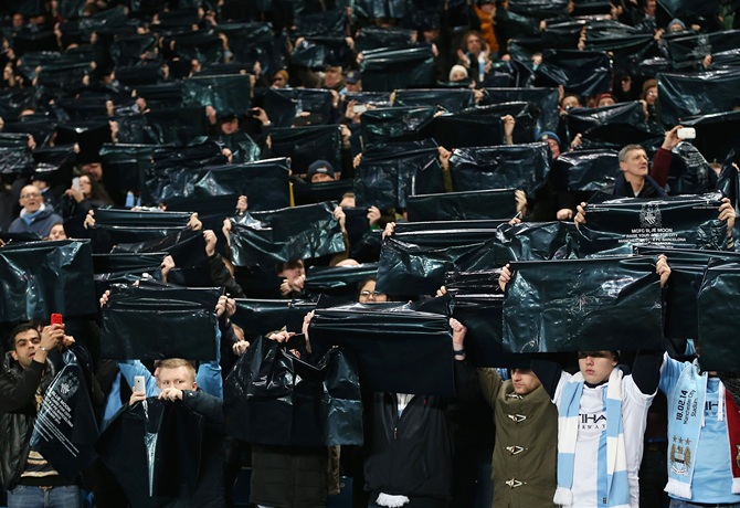 Manchester City fans hold up banners prior to the UEFA Champions League Round of 16 first leg match.