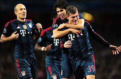 Toni Kroos of Bayern Munich celebrates scoring the opening goal with teammates Javi Martinez and Arjen Robben during the UEFA Champions League Round of 16 first leg match against Arsenal at Emirates Stadium in London on Wednesday