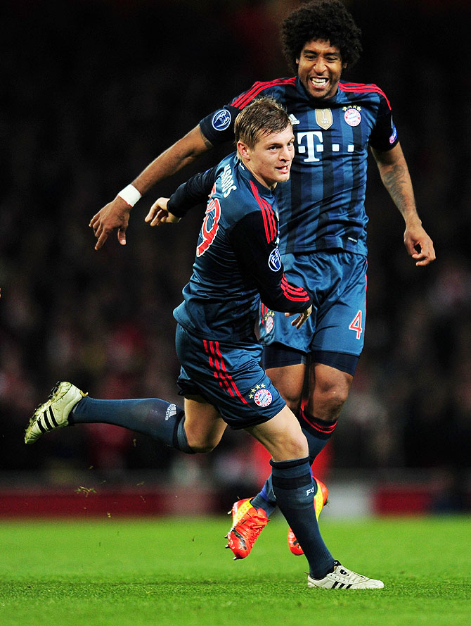 Toni Kroos of Bayern Muenchen celebrates scoring the opening goal with teammate Dante during their UEFA Champions League Round of 16 first leg match against Arsenal at Emirates Stadium in London on Wednesday