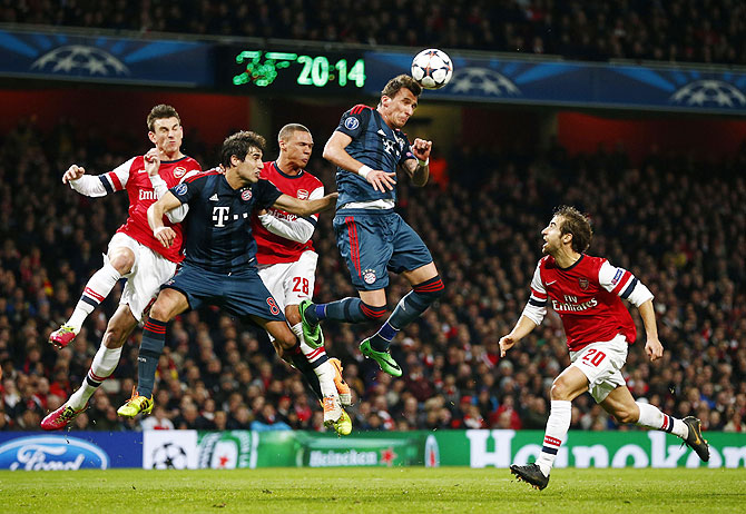 Bayern Munich's Mario Mandzukic (2nd from) and Javi Martinez (2nd from left) vie for the ball in an aerial challenge against Arsenal's Laurent Koscielny (left), Kieran Gibbs (centre) and Mathieu Flamini (right)