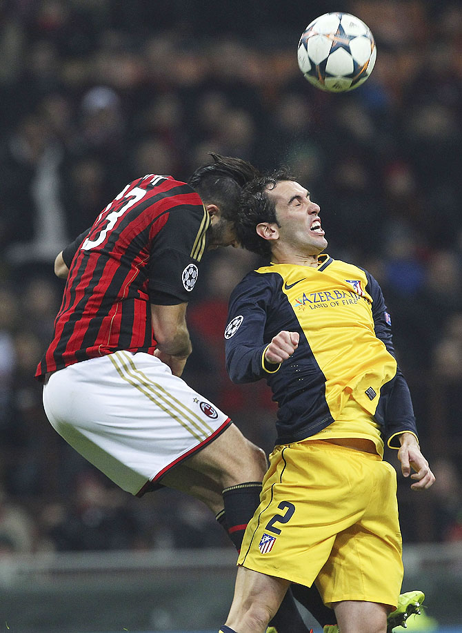 Diego Godin (right) of Atletico Madrid competes for the ball with Adil Rami (left) of AC Milan on Wednesday
