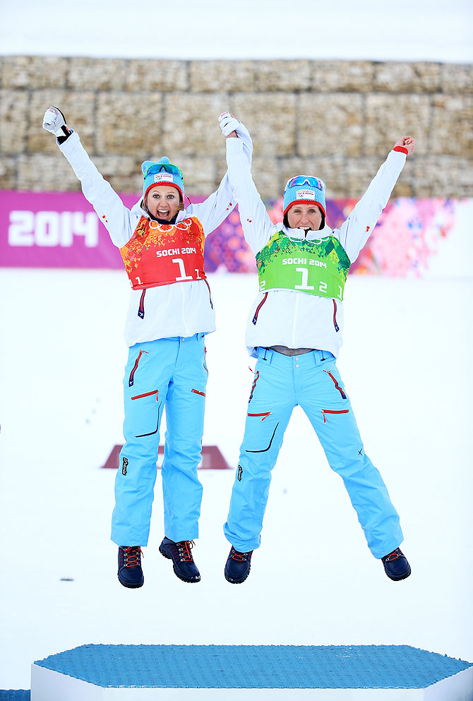 Gold medalists Marit Bjoergen (right) of Norway and teammate Ingvild Flugstad Oestberg celebrate during the flower ceremony for the Women's Team Sprint Classic Final on Wednesday