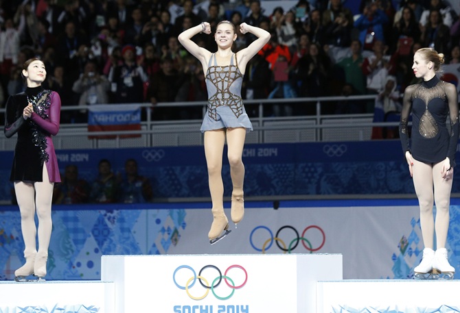 From left, Russia's Adelina Sotnikova celebrates in first place, Korea's Yuna Kim stands in second place and Italy's Carolina Kostner stands in third place on the podium.