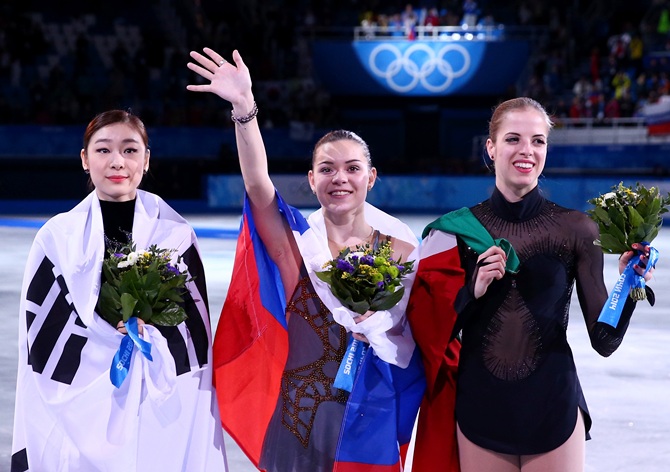 From Left, Silver medalist Yuna Kim of South Korea, gold medalist Adelina Sotnikova of Russia and bronze   medalist Carolina Kostner of Italy celebrate during the flower ceremony for the Ladies' Figure Skating.