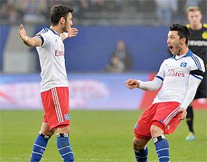 Hamburg's Turkish midfielder Hakan Calhanoglu (left) celebrates with teammate Tolgay Arslan after theirBundesliga match against Borussia Dortmund on Saturday