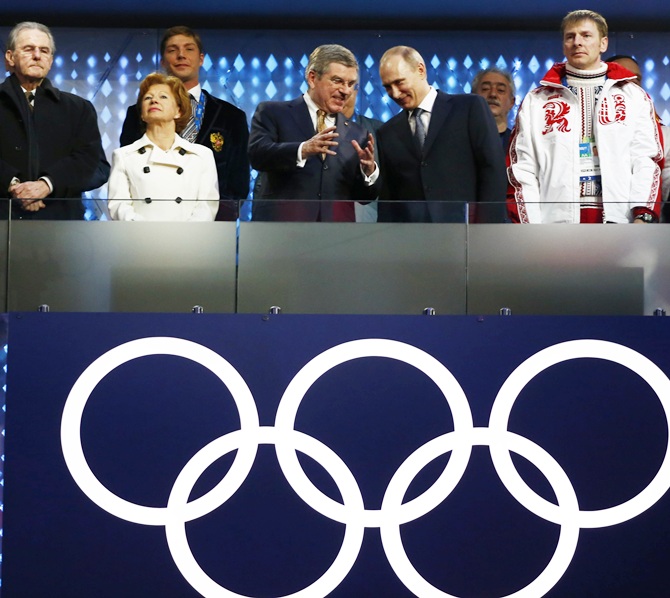 Russia's President Vladimir Putin talks with International Olympic Committee (IOC) President Thomas Bach, as Former President of the International Olympic Committee Jacques Rogge looks on, left, at the start of the closing ceremony.