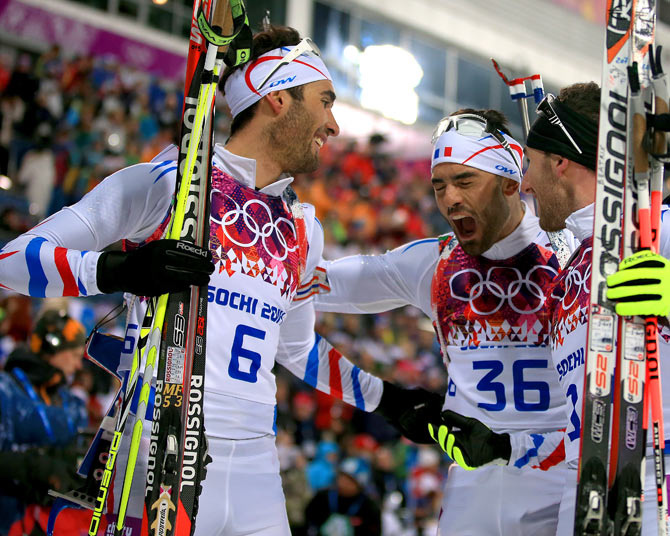 France's gold medalist Martin Fourcade (left) celebrates with brother Simon Fourcade (centre) at the   finish area after the men's 12.5 km Pursuit at Laura Cross-country Ski & Biathlon Center during the Sochi Winter Olympics.