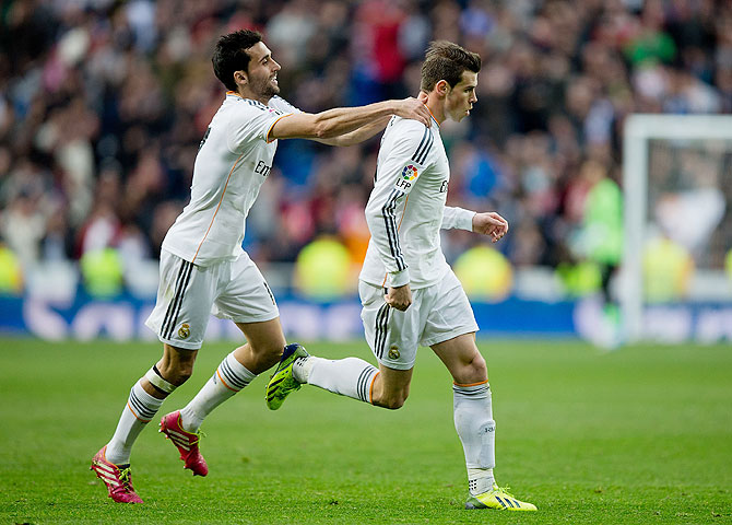 Real Madrid's Gareth Bale (right) celebrates with teammate Alvaro Arbeloa after scoring against Elche CF during their La Liga match at Estadio Santiago Bernabeu on Saturday