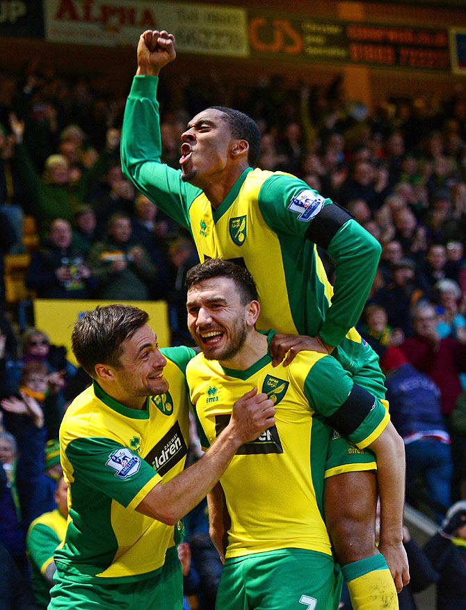 Robert Snodgrass of Norwich City (centre) celebrates with teammates Leroy Fer and Russell Martin after scoring the opening goal against Tottenham Hotspur at Carrow Road in Norwich on Sunday