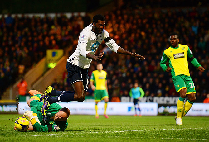 John Ruddy of Norwich City clashes with Emmanuel Adebayor of Tottenham Hotspur during their match on Sunday