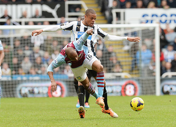 Loic Remy of Newcastle United tackles Fabian Delph of Aston Villa during their Premier League match at St James' Park in Newcastle on Sunday