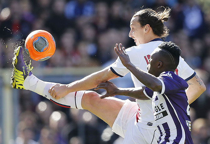 Paris St Germain's Zlatan Ibrahimovic challenges Toulouse's Steev Yago (right) during their French Ligue 1 match at the stadium in Toulouse