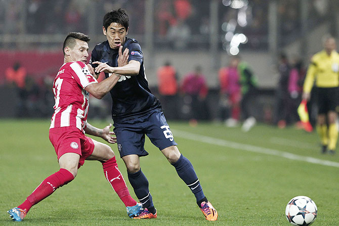 Olympiakos' Hernan Perez (left) challenges Manchester United's Shinji Kagawa during their Champions League match on Tuesday