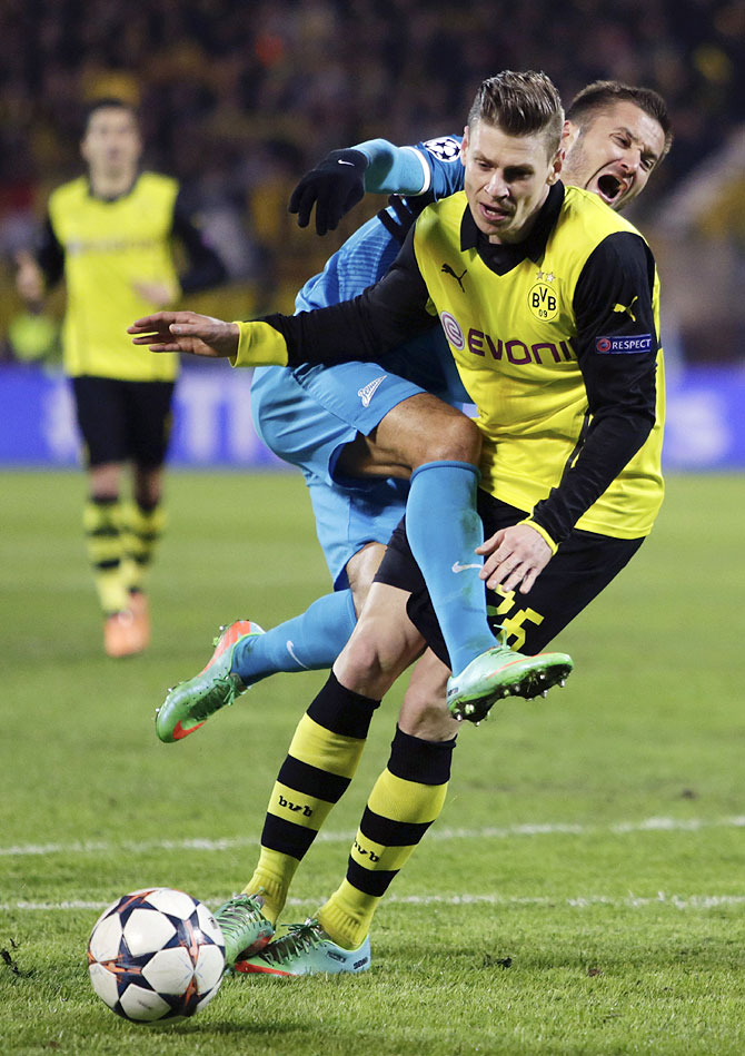 Zenit St Petersburg's Viktor Fayzulin and Borussia Dortmund's Lukasz Piszczek (right) get into a tangle as they fight for the ball during their Champions League match on Tuesday