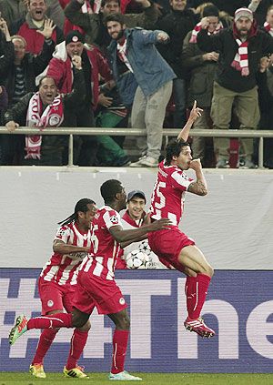 Olympiakos's Alejandro Dominguez (right) celebrates with his teammates after scoring a goal against Manchester United during their Champions League round of 16 first leg match at Karaiskaki stadium in Piraeus, near Athens, on Tuesday