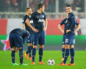 Wayne Rooney, Michael Carrick and Robin van Persie of Manchester United react as they restart the game after conceding the first goal during their UEFA Champions League Round of 16 first leg match against Olympiacos at Karaiskakis Stadium on Tuesday