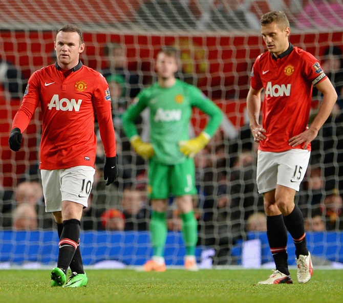 Wayne Rooney of Manchester United and his team-mate Nemanja Vidic (right) react after conceding a second goal