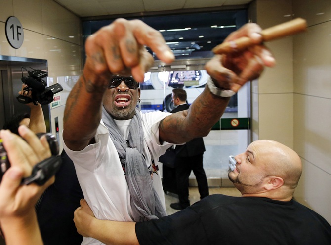 Former basketball star Dennis Rodman of the US gestures as he talks to journalists chasing him upon his arrival at Beijing