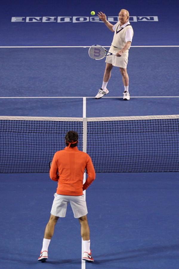 Rod Laver plays a backhand against Roger Federer