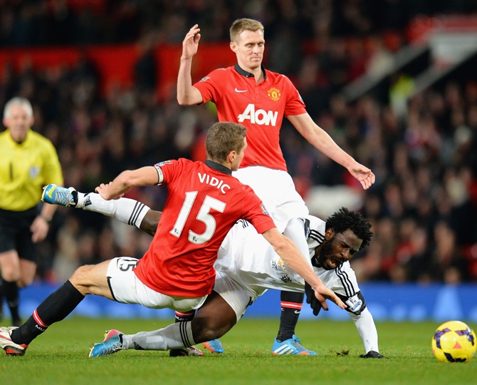 Wilfried Bony of Swansea City is challenged by Nemanja Vidic of Manchester United