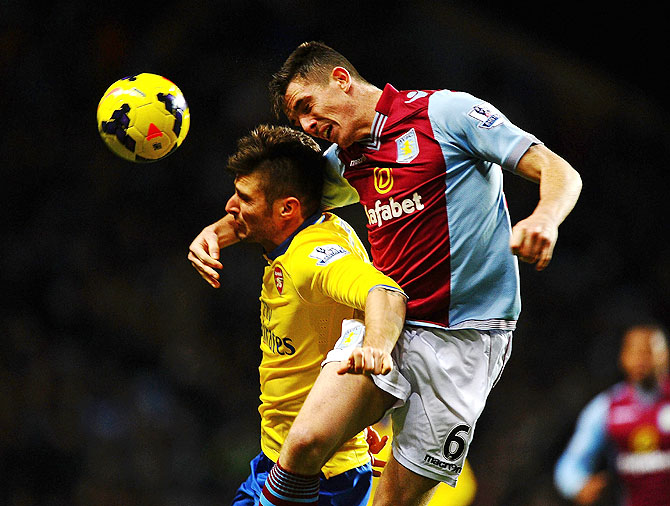 Ciaran Clark of Aston Villa challenges Olivier Giroud of Arsenal during their match on Monday