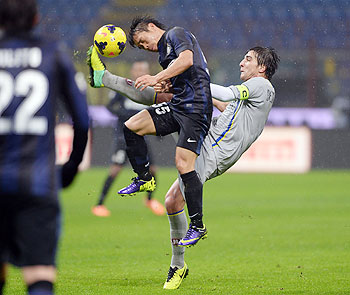 Yuto Nagatomo of Inter Milan (left) and Simone Bentivoglio of AC Chievo Verona vie for the ball during their Serie A match at San Siro Stadium in Milan on Monday