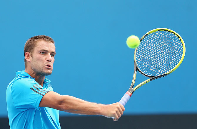 Mikhail Youzhny of Russia plays a backhand in his second round match against Florian Mayer of Germany at the Australian Open at Melbourne Park on Wednesday