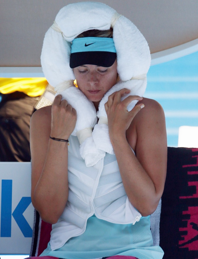 Maria Sharapova of Russia holds an ice-packed towel to her head while wearing an ice vest during a break