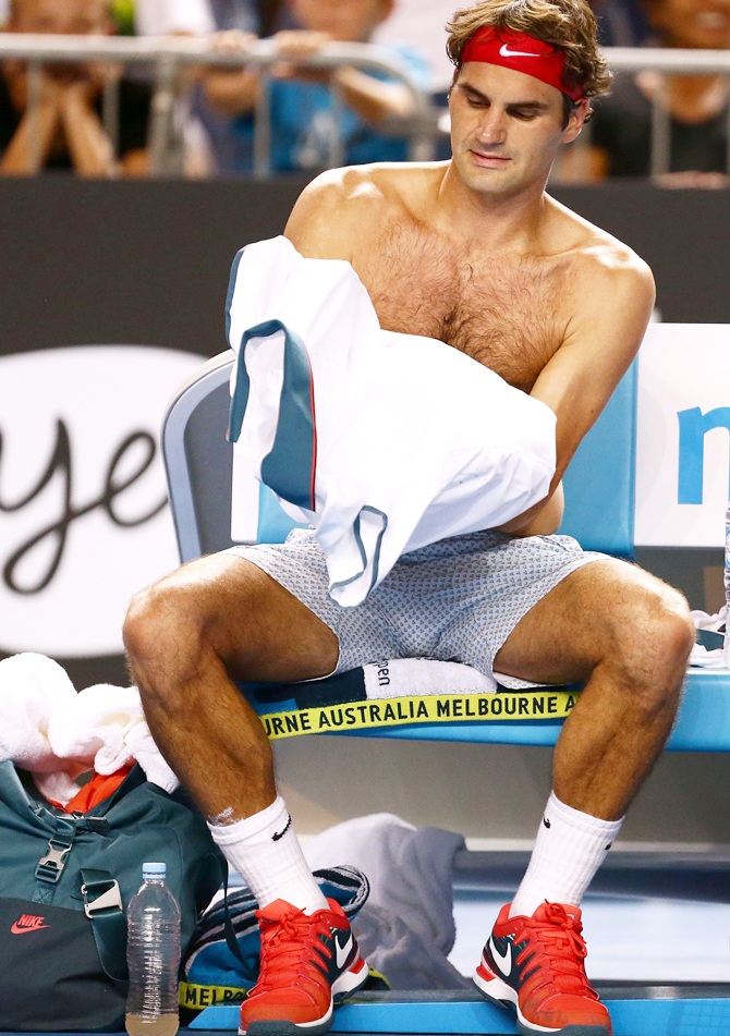 Roger Federer of Switzerland changes his shirt to cool off