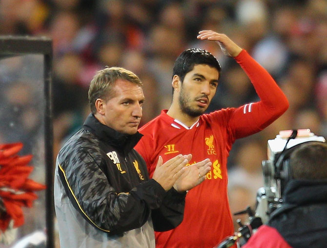 Liverpool FC Manager Brendan Rodgers (left) looks on as Luis Suarez is substituted