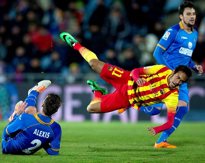 Neymar of FC Barcelona is tackled by Alexis Ruano of Getafe