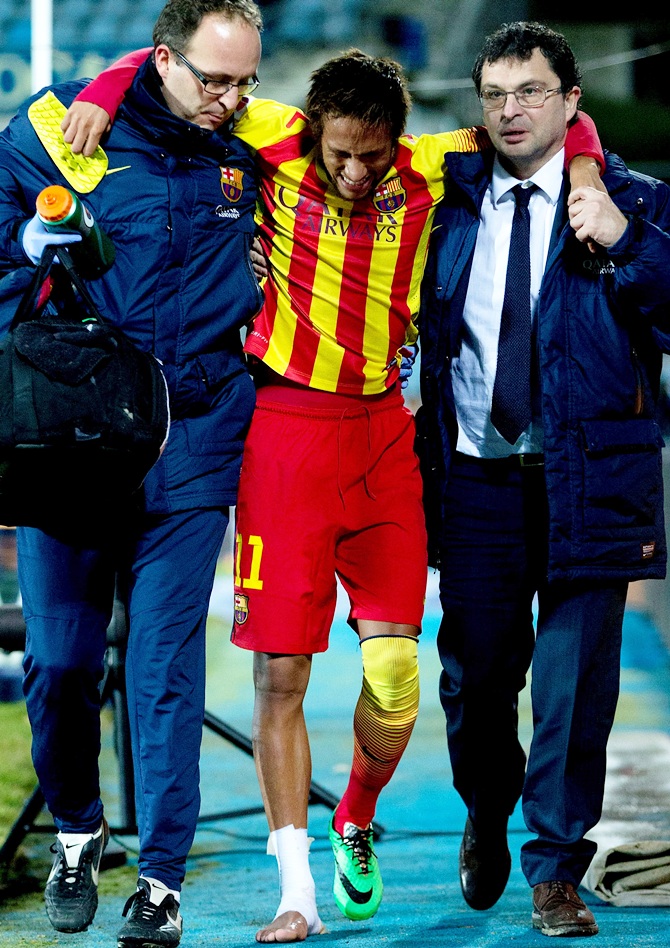 Neymar of Barcelona is assisted as he leaves the pitch after picking up an injury