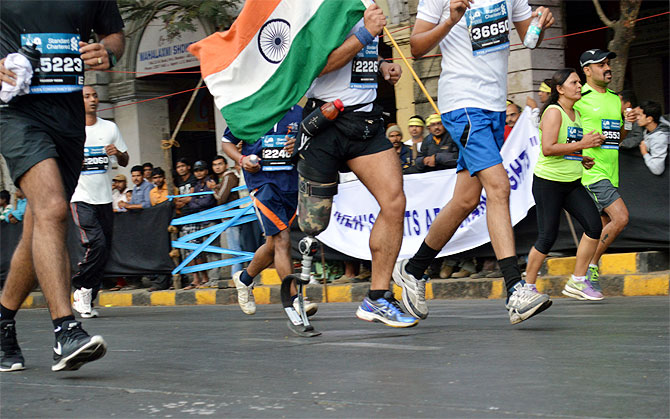 A runner with an amputated leg runs with the India flag